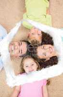 Composite image of smiling family lying on the rug in a circle