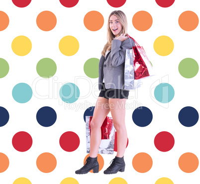 Composite image of stylish blonde holding shopping bags Composite image of stylish blonde holding shopping bags