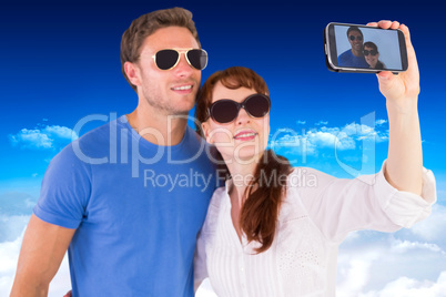 Composite image of couple using camera for picture