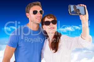 Composite image of couple using camera for picture