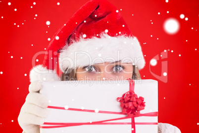 Composite image of festive blonde holding a gift