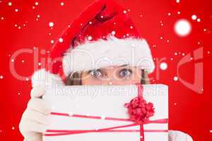 Composite image of festive blonde holding a gift