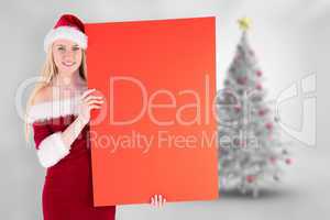 Composite image of festive cute blonde holding poster