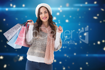 Composite image of brown hair in winter clothes holding shopping