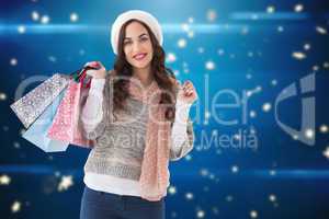Composite image of brown hair in winter clothes holding shopping