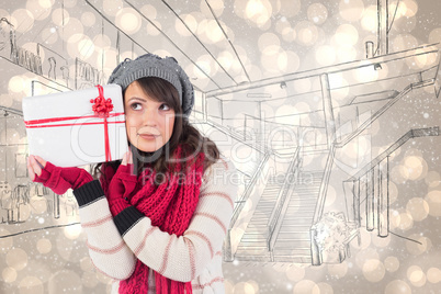 Composite image of festive brunette holding white and red gift