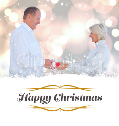 Composite image of couple exchanging gift