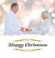 Composite image of couple exchanging gift