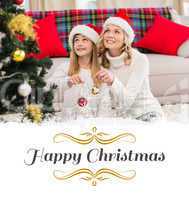 Composite image of festive mother and daughter decorating christ