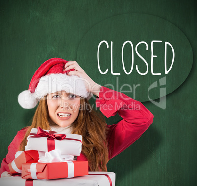 Festive stressed redhead holding gifts