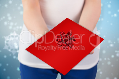 Composite image of woman holding red and white gift