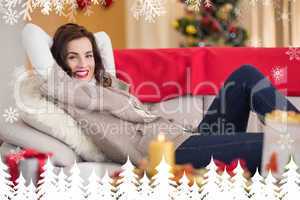 Composite image of smiling brunette relaxing on the couch at chr