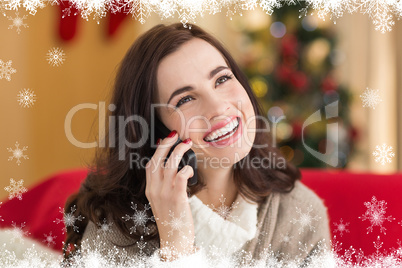 Composite image of smiling brunette on the phone on christmas da
