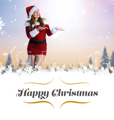 Composite image of pretty girl in santa costume holding hand out