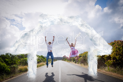 Composite image of excited couple jumping on the road