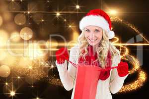 Composite image of happy festive blonde with shopping bag