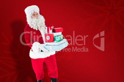 Composite image of father christmas holding many gifts