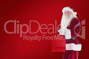 Composite image of santa carries red gift bag