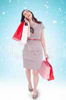 Composite image of happy brunette with shopping bags on the phon