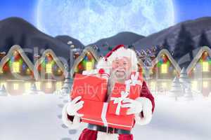 Composite image of santa carrying gifts in the snow