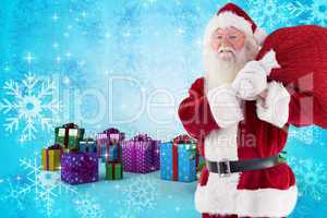 Composite image of santa carries his red bag and smiles