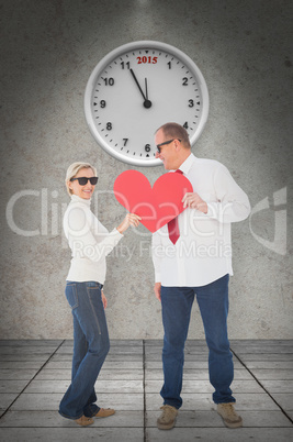 Composite image of older affectionate couple holding red heart s