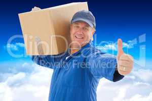 Composite image of happy delivery man holding cardboard box