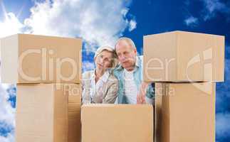 Composite image of stressed older couple with moving boxes