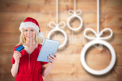 Composite image of festive blonde shopping online with tablet