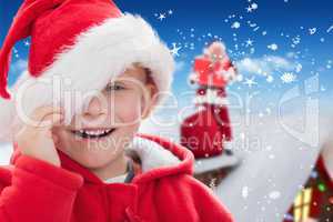 Composite image of cute boy in santa hat