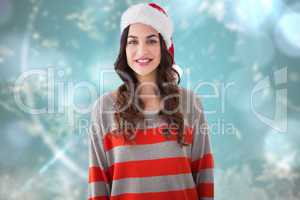 Composite image of beautiful brunette in santa hat smiling at ca