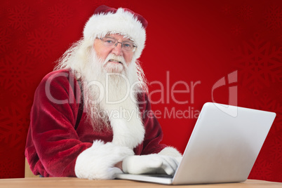 Composite image of santa surfs on the internet