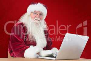 Composite image of santa surfs on the internet