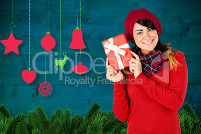 Composite image of brunette in red hat holding a gift