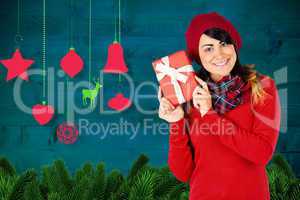 Composite image of brunette in red hat holding a gift