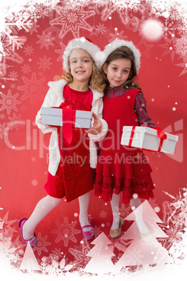 Composite image of festive little girls smiling at camera with gifts
