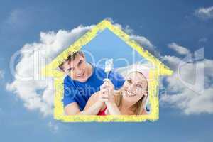 Composite image of hugging couple having fun while painting a ro