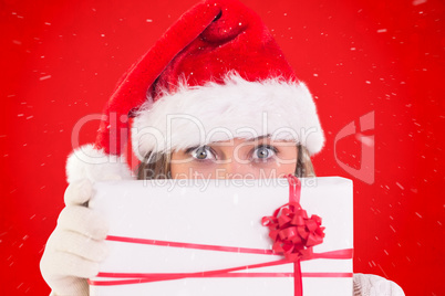 Composite image of festive blonde holding a gift