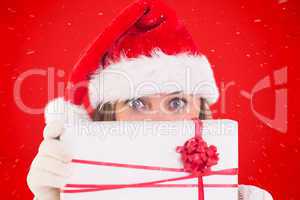 Composite image of festive blonde holding a gift