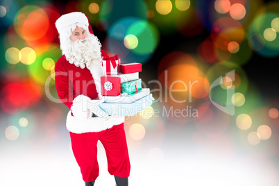 Composite image of father christmas holding many gifts