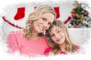 Composite image of festive mother and daughter smiling at camera
