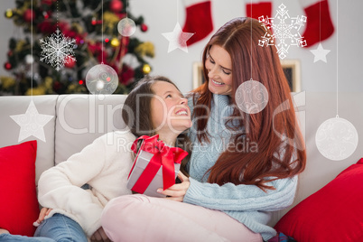 Composite image of festive mother and daughter on the couch with