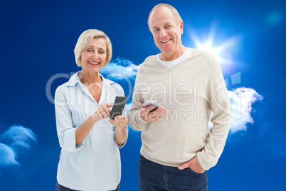 Composite image of happy mature couple using their smartphones