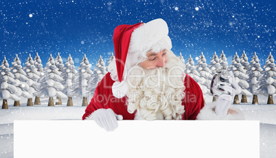 Composite image of happy santa holding alarm clock and sign