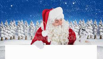 Composite image of happy santa holding alarm clock and sign