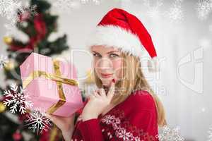 Composite image of festive woman standing holding a pink gift