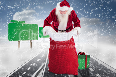 Composite image of santa looks in his bag