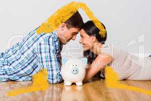 Composite image of young couple lying on floor smiling with pigg
