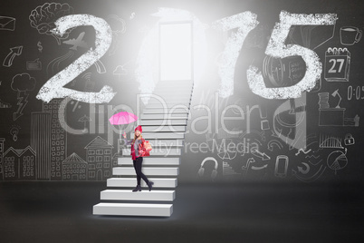 Composite image of festive blonde holding umbrella and bags