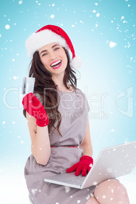 Composite image of smiling brunette shopping online with laptop